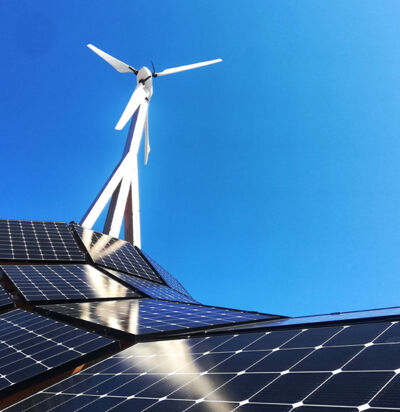 Solarzellen und Windrad vor blauem Himmel