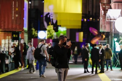 Fotograf in einer Messehalle, der gerade ein Foto macht