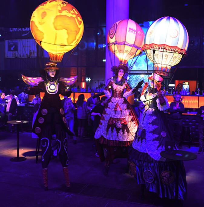 Drei Menschen in Kostümen auf Stelzen