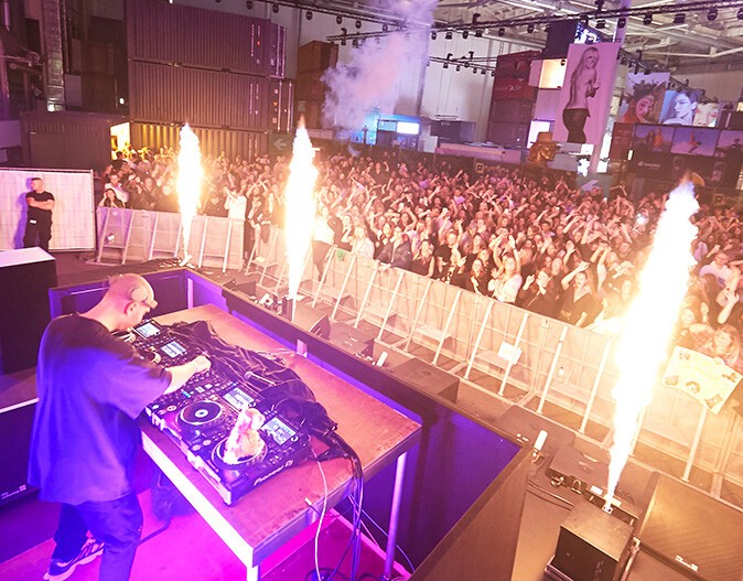 Ein DJ bei der PHOTOPIA 2022 mit Blick zu den feiernden Gästen