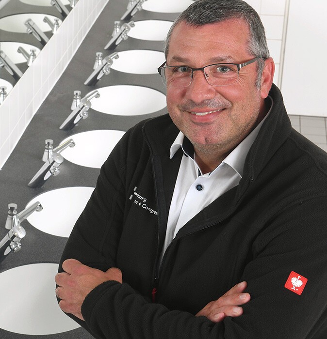 Alexander Peters im Portrait mit Waschbecken im Hintergrund