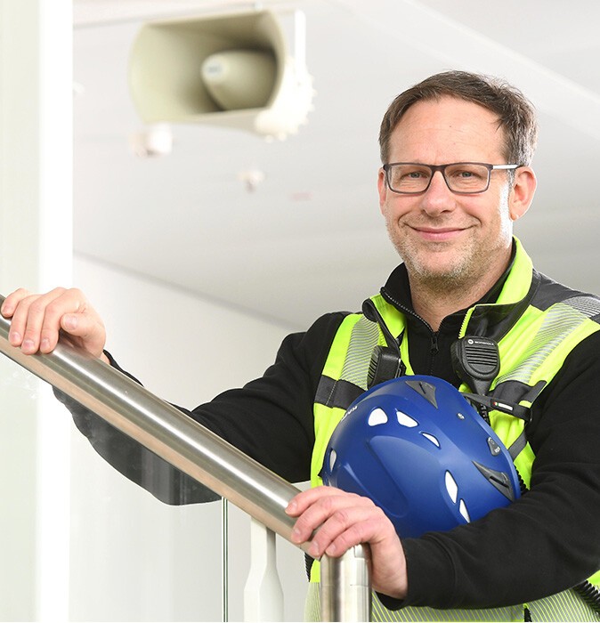 Florian Röner im Portrait mit dem Lautsprecher im Hintergrund